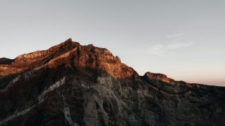a very tall mountain with a sky in the background