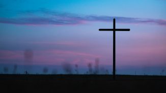 cross stand under purple and blue sky